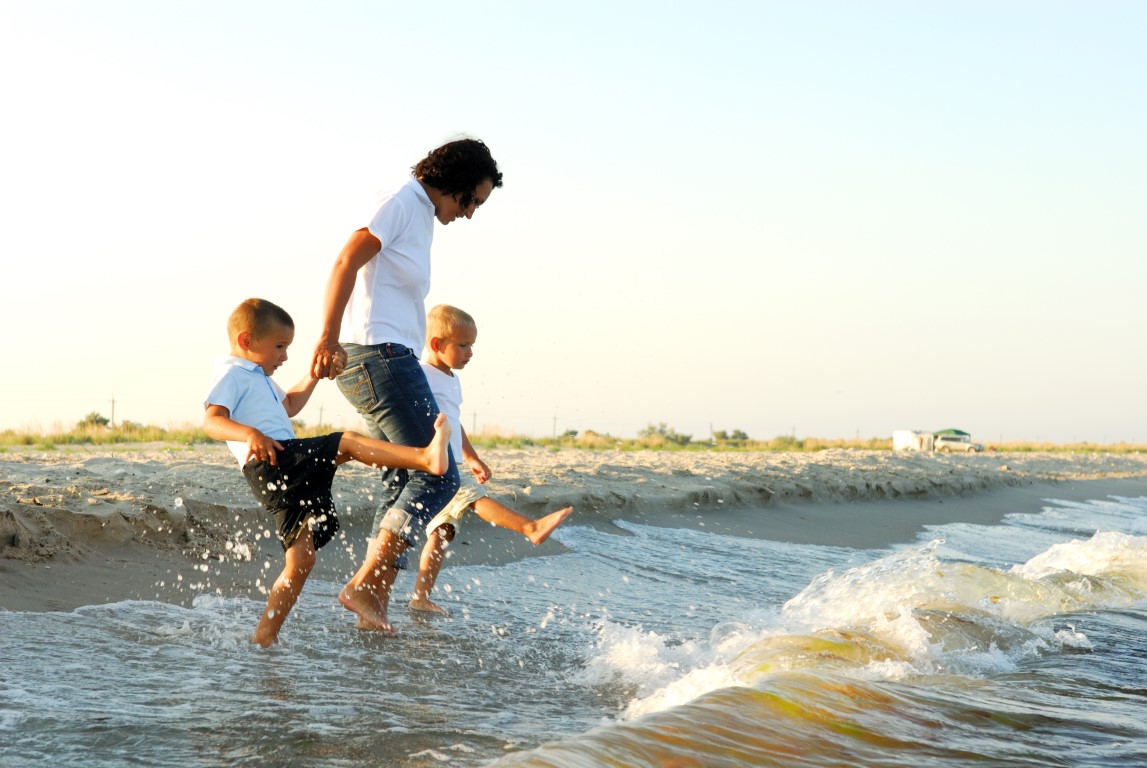 A family splashing in the waves at the beach.